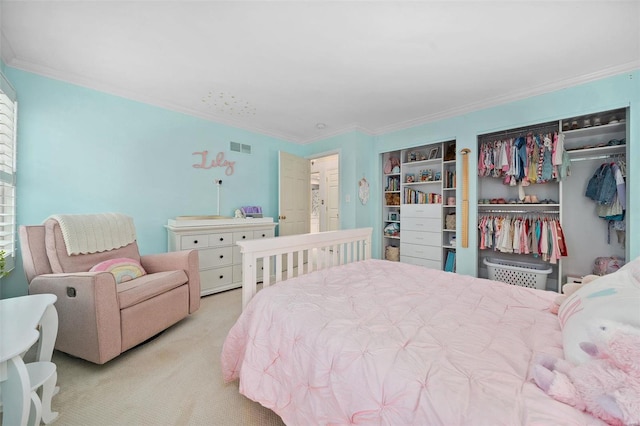 bedroom featuring crown molding, light carpet, and a closet