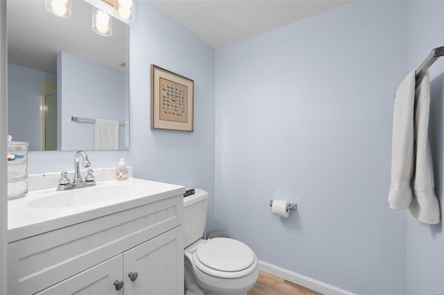 bathroom featuring toilet, vanity, and hardwood / wood-style flooring