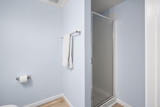 bathroom featuring hardwood / wood-style floors and a shower with door