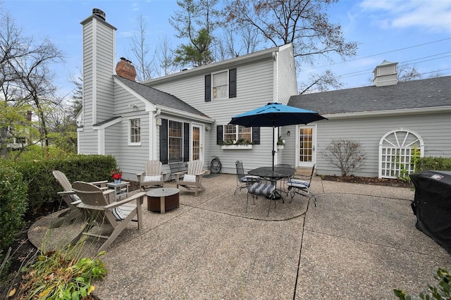 rear view of property with an outdoor fire pit and a patio area