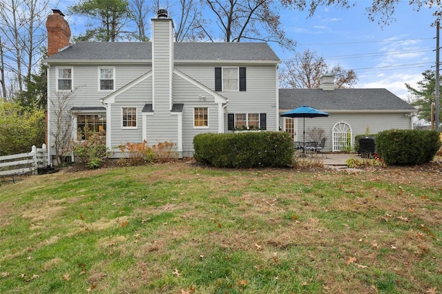 rear view of house featuring a yard and a patio