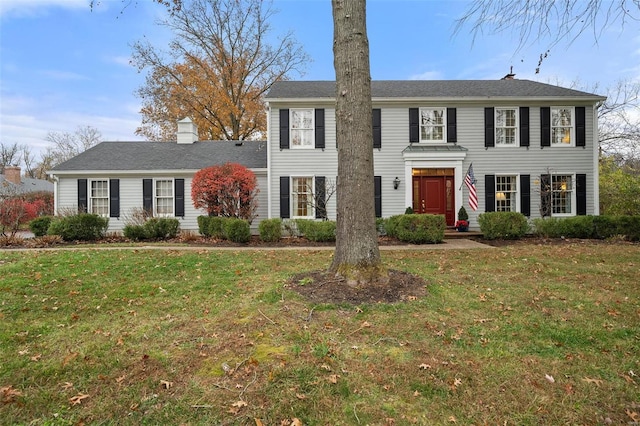 colonial inspired home with a front lawn