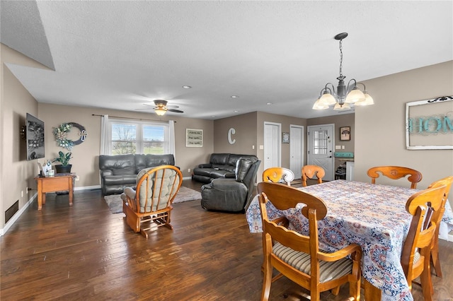 dining space featuring ceiling fan with notable chandelier, a textured ceiling, and dark hardwood / wood-style flooring