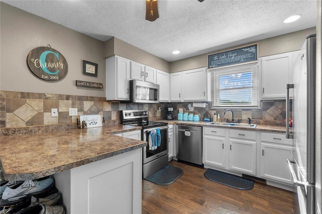 kitchen featuring white cabinets, sink, dark hardwood / wood-style floors, kitchen peninsula, and stainless steel appliances