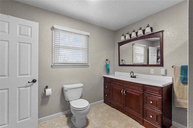 bathroom featuring tile patterned flooring, vanity, a textured ceiling, and toilet