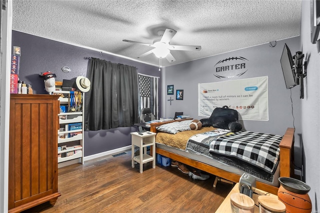 bedroom with ceiling fan, dark hardwood / wood-style flooring, and a textured ceiling