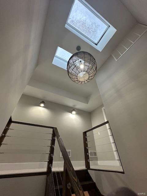 stairs with a towering ceiling and a skylight