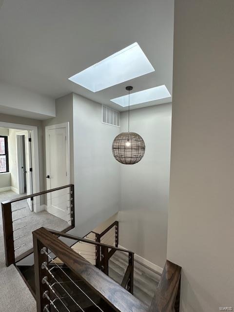 staircase featuring wood-type flooring and a skylight