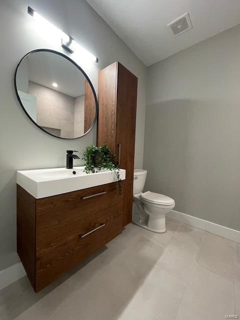 bathroom with tile patterned flooring, vanity, and toilet