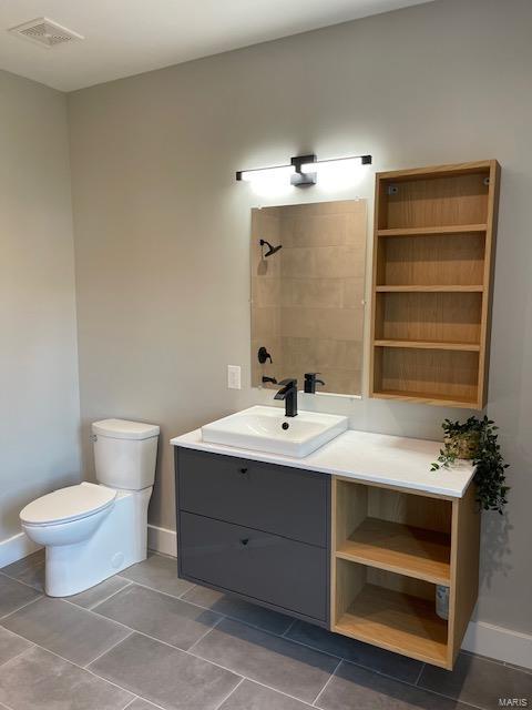 bathroom with tile patterned floors, vanity, and toilet