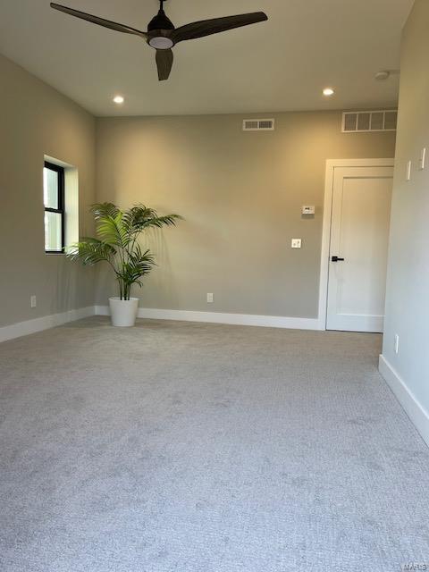 unfurnished room with ceiling fan and light carpet