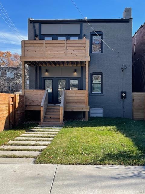 view of front of property with a balcony and a front yard