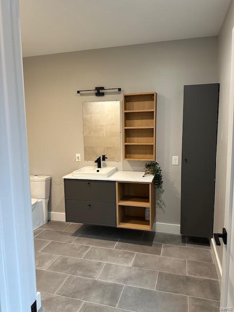 bathroom with tile patterned flooring, vanity, and toilet