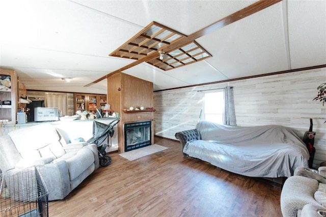 living room featuring wood walls, wood-type flooring, and lofted ceiling