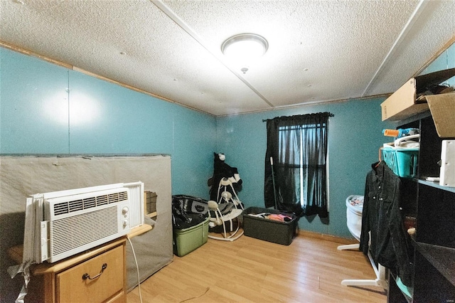 office featuring a textured ceiling, light hardwood / wood-style floors, and a wall unit AC