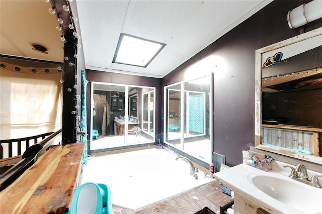 bathroom featuring vanity, crown molding, a tub, and a skylight