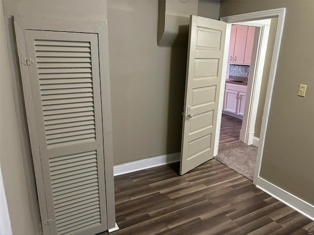 unfurnished bedroom with a closet and dark wood-type flooring