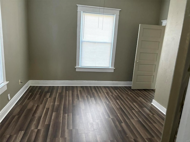 empty room featuring a healthy amount of sunlight and dark wood-type flooring