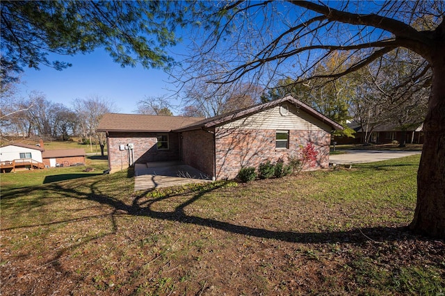 view of side of home featuring a yard and a patio