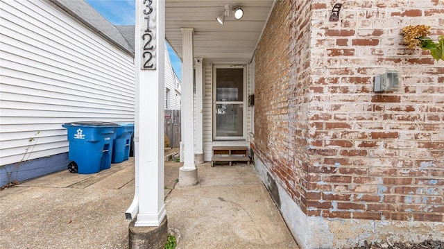 entrance to property featuring brick siding