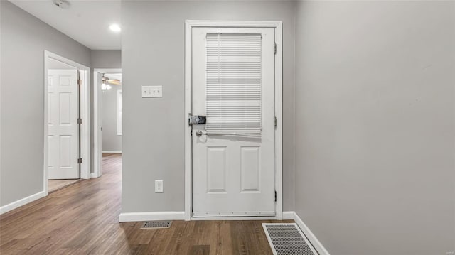 entryway featuring visible vents, baseboards, and wood finished floors