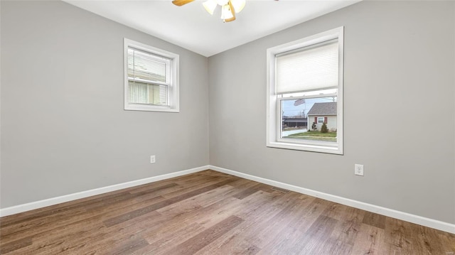 spare room with ceiling fan, baseboards, and wood finished floors