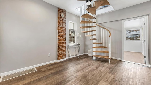 staircase featuring baseboards and wood finished floors