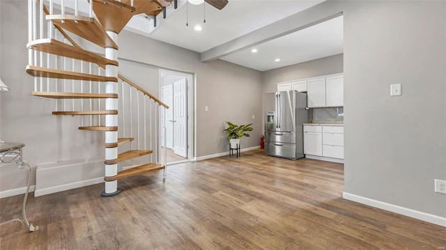 interior space with baseboards, stairway, ceiling fan, and wood finished floors