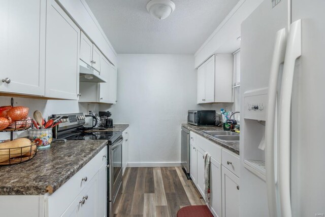 kitchen with sink, dark hardwood / wood-style flooring, white cabinetry, and stainless steel appliances