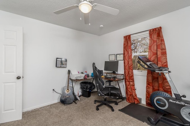 carpeted home office with ceiling fan and a textured ceiling