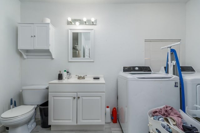 bathroom featuring vanity, toilet, and washing machine and clothes dryer