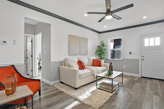 living room featuring light hardwood / wood-style floors, ceiling fan, and ornamental molding