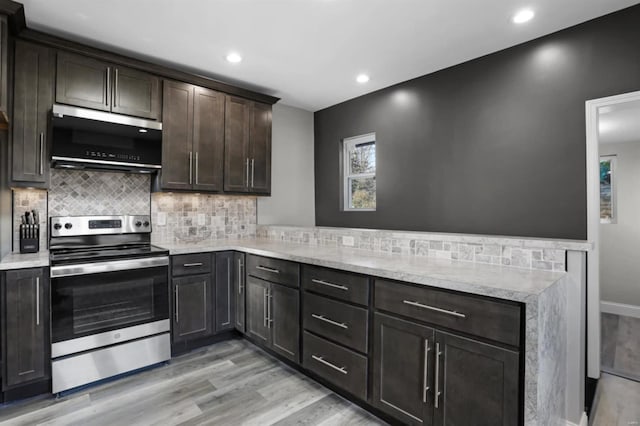 kitchen featuring light stone counters, light hardwood / wood-style floors, decorative backsplash, dark brown cabinets, and appliances with stainless steel finishes