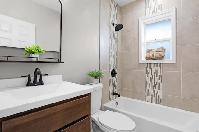 full bathroom featuring vanity, tiled shower / bath combo, and toilet