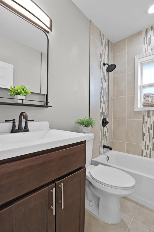 full bathroom featuring tile patterned floors, vanity, tiled shower / bath combo, and toilet