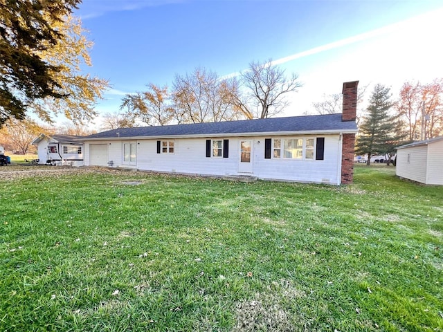 back of property with a lawn and a garage