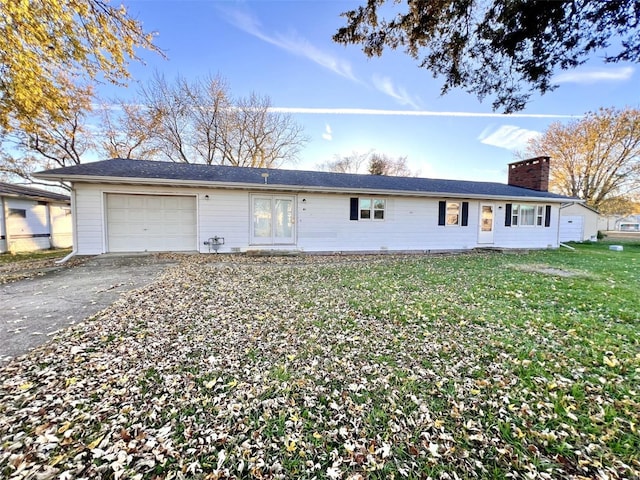 ranch-style home featuring french doors, a front lawn, and a garage