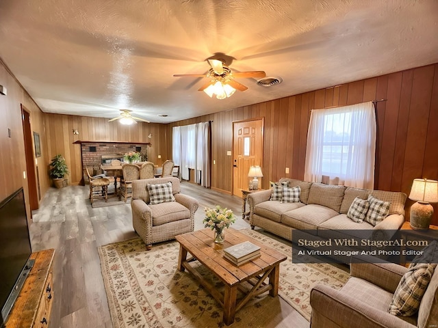 living room with hardwood / wood-style flooring, ceiling fan, and a textured ceiling