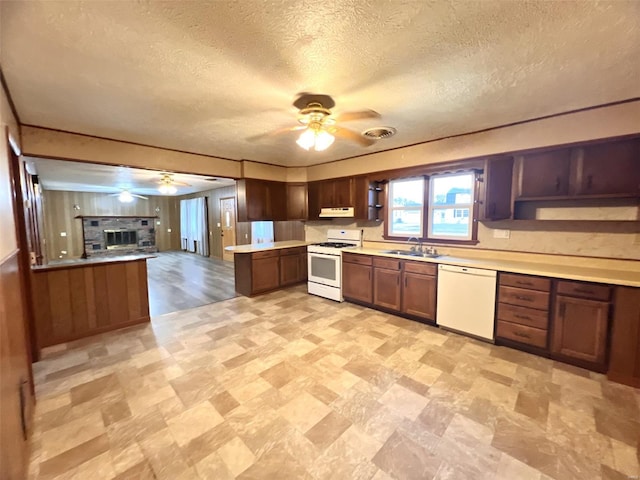 kitchen with kitchen peninsula, a textured ceiling, white appliances, ceiling fan, and sink