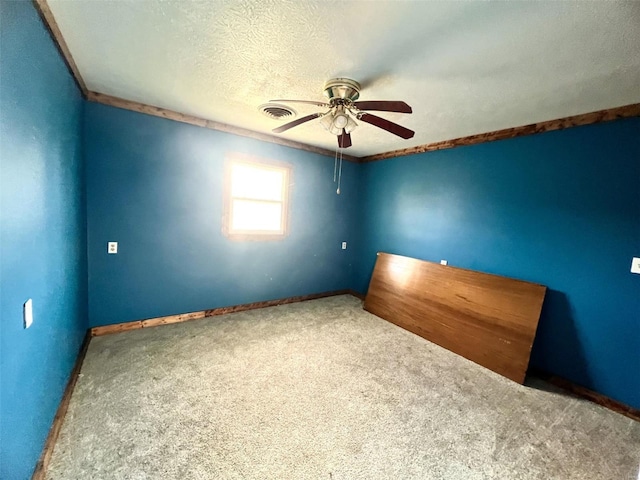 carpeted spare room featuring a textured ceiling and ceiling fan