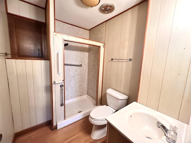 bathroom featuring hardwood / wood-style floors, vanity, toilet, ornamental molding, and walk in shower