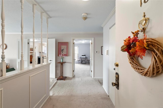 hall with light carpet, a textured ceiling, and crown molding