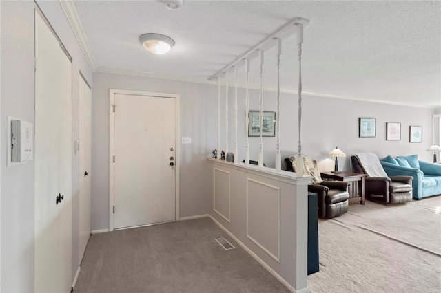 corridor featuring carpet, crown molding, and a textured ceiling