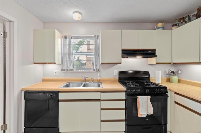 kitchen featuring black appliances, sink, and a textured ceiling