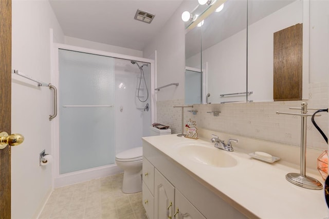 bathroom featuring decorative backsplash, toilet, vanity, and walk in shower