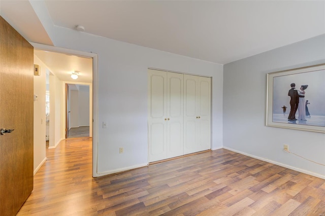 unfurnished bedroom featuring a closet and light hardwood / wood-style floors