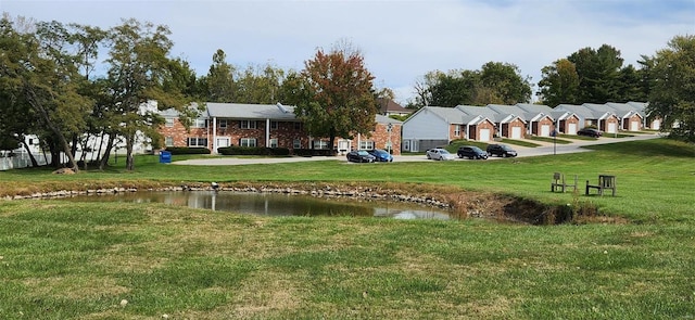 surrounding community featuring a lawn and a water view