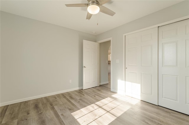 unfurnished bedroom with ceiling fan, light wood-type flooring, and a closet