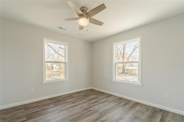 unfurnished room with a wealth of natural light, ceiling fan, and light hardwood / wood-style floors