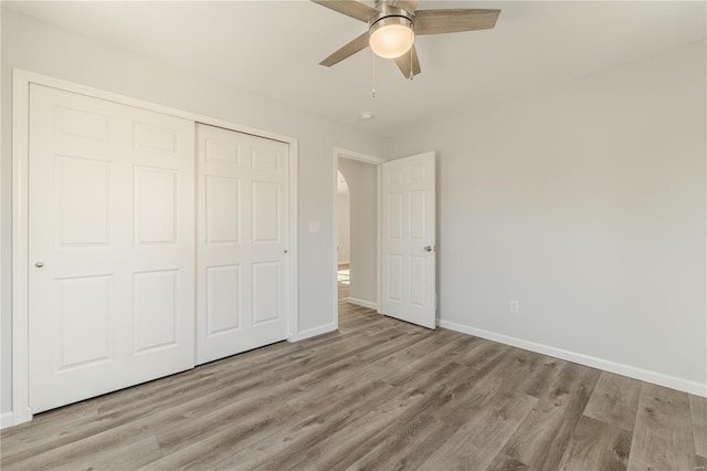 unfurnished bedroom with light wood-type flooring, a closet, and ceiling fan